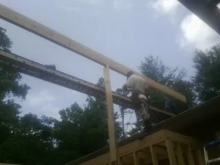 Carpenter setting a ridge beam over a new addition frame — Ice Dam Removal by Roofing Brothers in Hilton