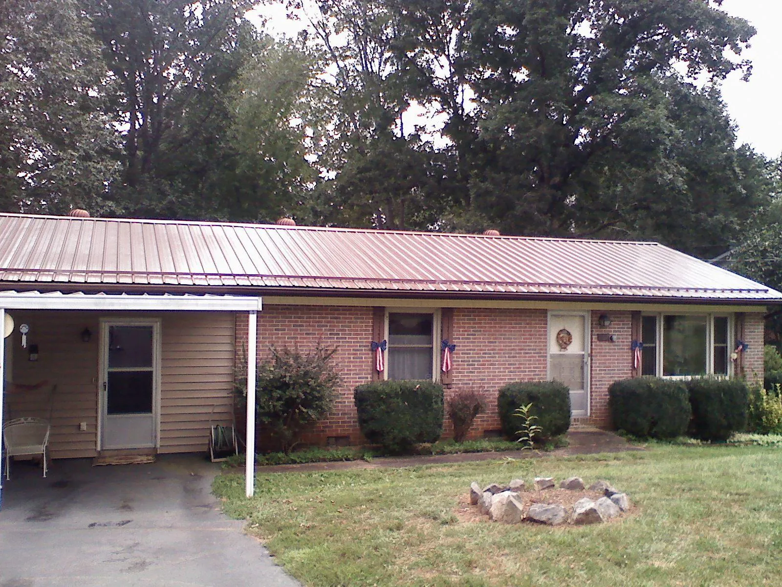 Bronze metal roof and carport on a brick ranch home — Roof Repair work by our crew in Hilton